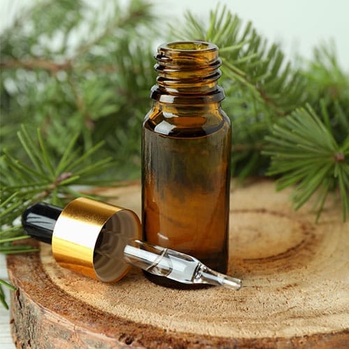 Zirbenöl bzw. Arvenöl in einer geöffneten kleinen Flasche. Die Pipette liegt daneben.